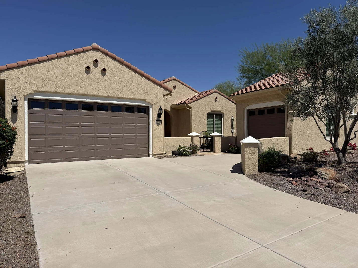 Refreshed tan stucco exterior with brown garage doors in Glendale, AZ