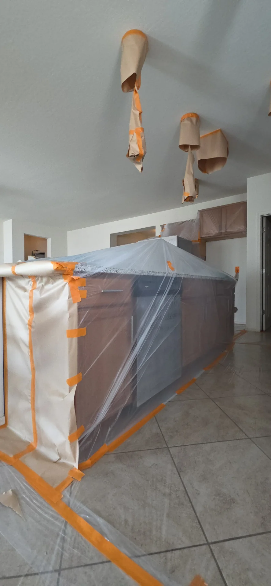 Kitchen island fully masked with plastic and paper before interior spraying in the West Valley