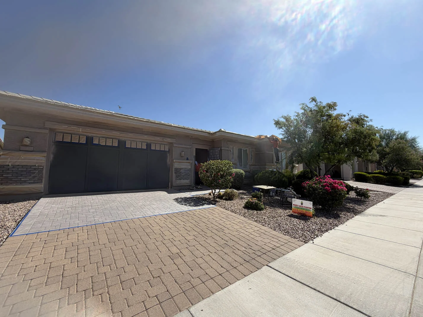 Painter's tape masking around a garage door before spraying in Glendale, AZ
