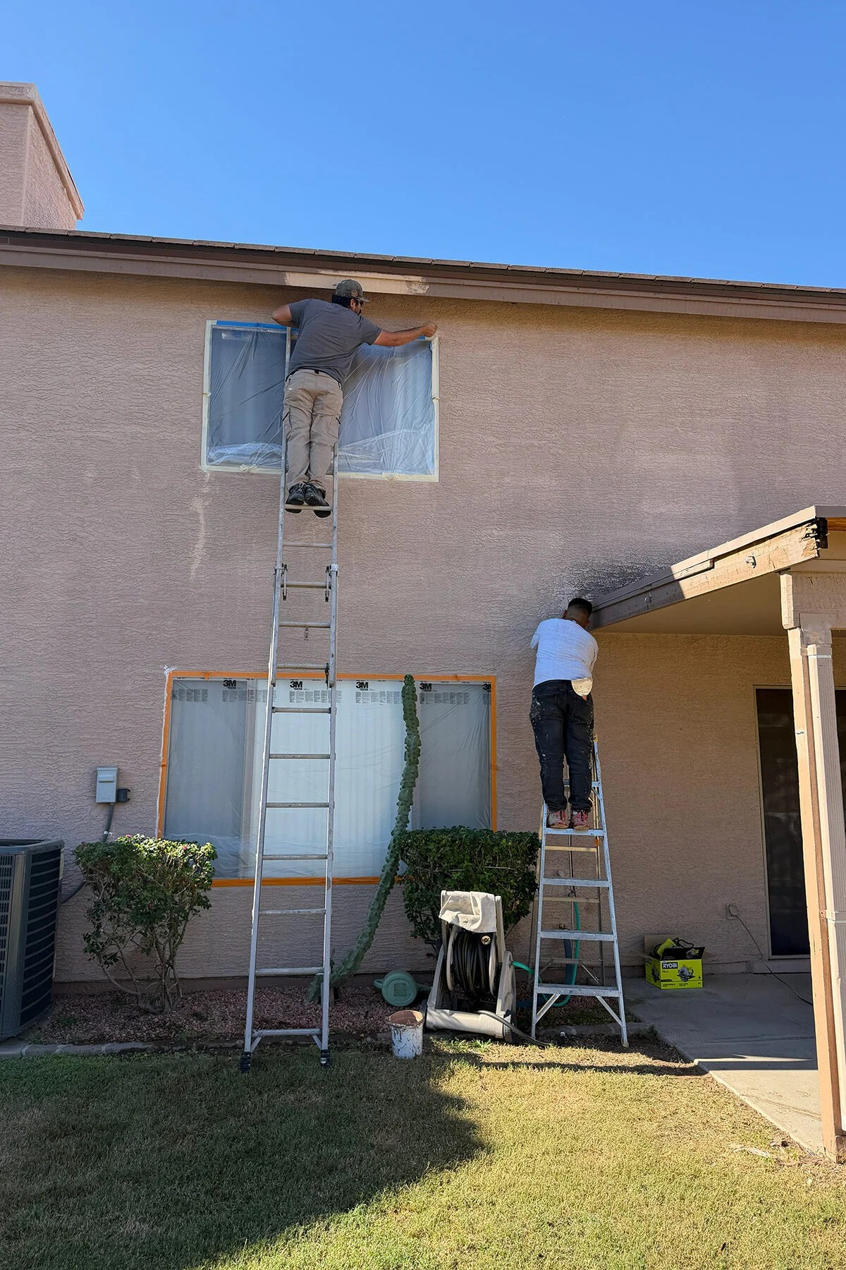 Desert Mesa Painting crew masking a two-story West Valley home before exterior painting
