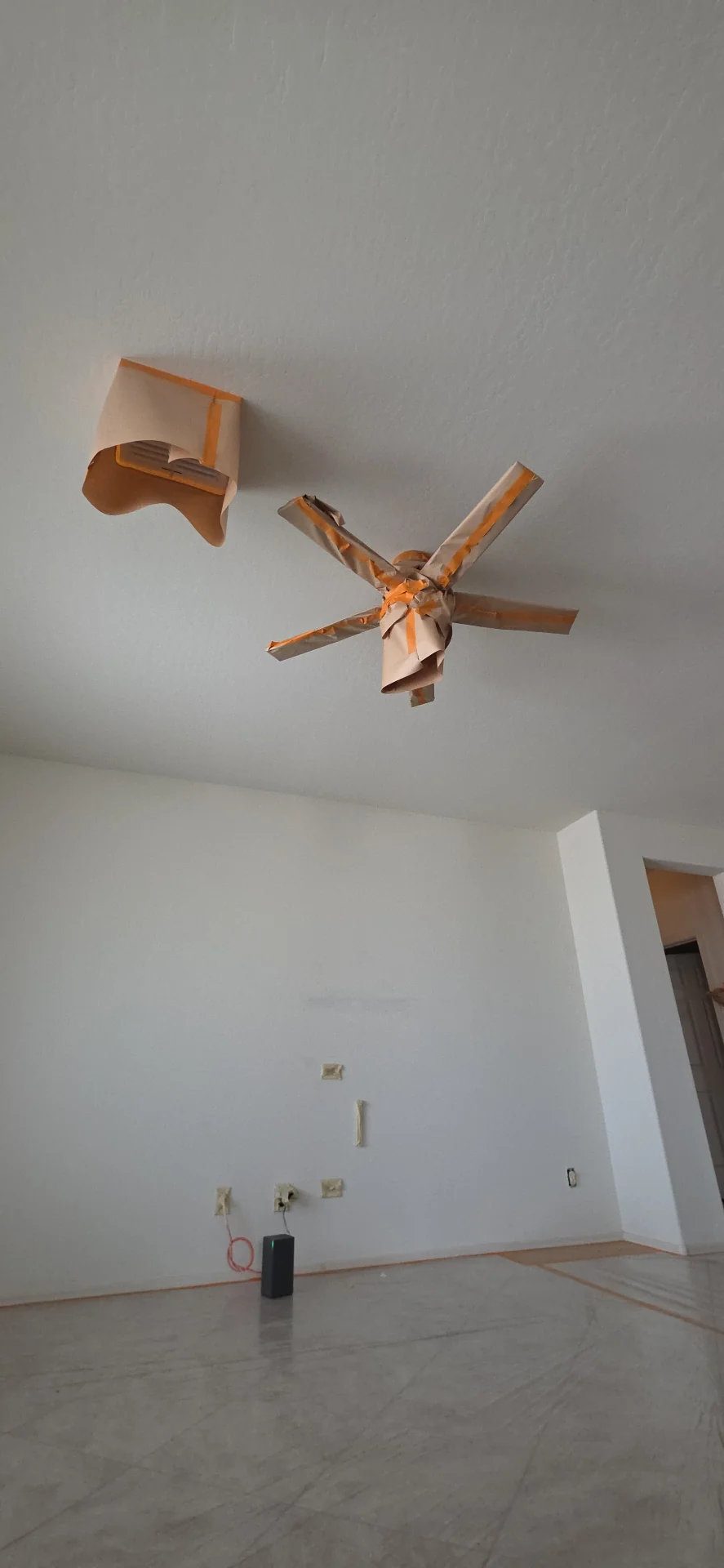 Ceiling fan wrapped and masked before an interior repaint in a Phoenix, AZ home