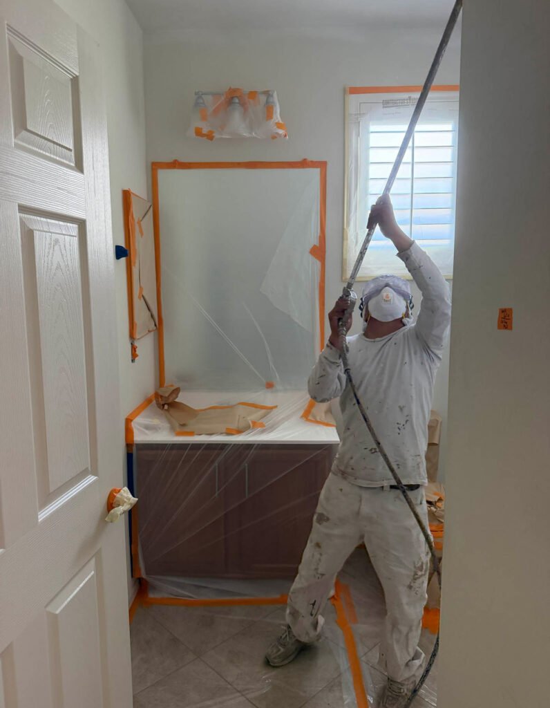 Interior painting crew preparing bathroom for precision work and seamless texture matching.