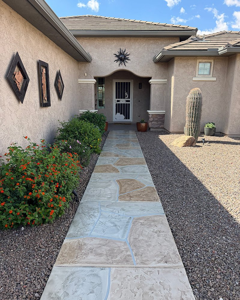 Arizona home exterior showcasing Desert Mesa Painting cement finishes and decorative stone walkway.